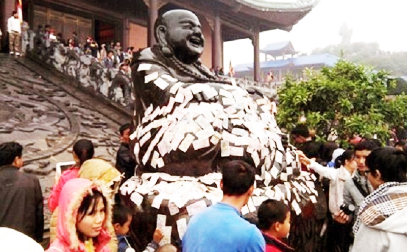 Nhét tiền vào tượng Phật và sự khủng hoảng về tâm linh của người Việt